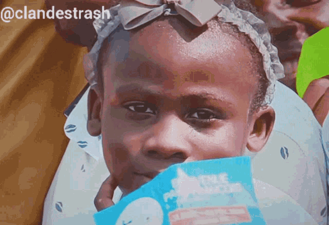 a little girl holding a box of pampers in her hand