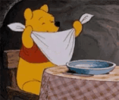 a cartoon of winnie the pooh sitting at a table