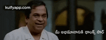 a man in a white shirt is smiling in a room with a foreign language .