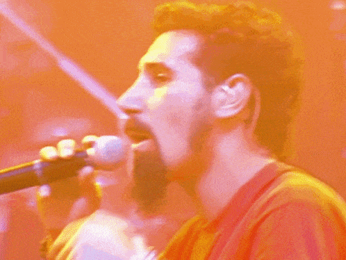 a man singing into a microphone with his mouth open