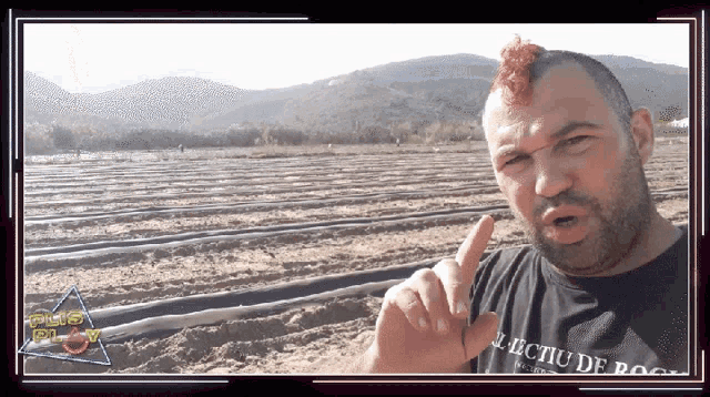 a man with a mohawk wearing a black shirt that says " lectiu de rock "