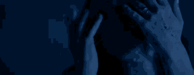a person 's hands are covered in soap bubbles in a dark room