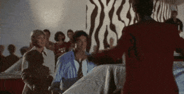 a man in a red jacket is standing in front of a crowd