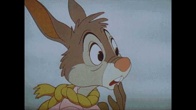 a close up of a cartoon rabbit with a yellow scarf around his neck