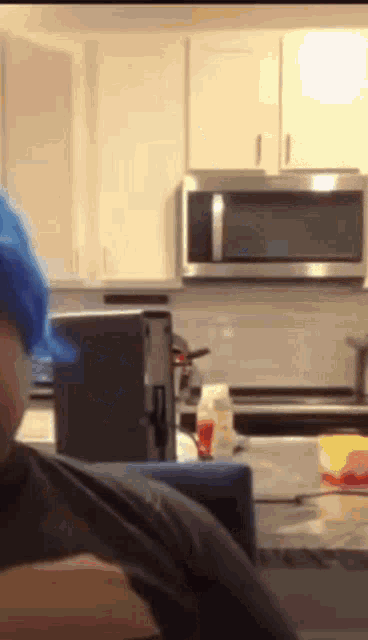 a man wearing a blue hat is in a kitchen