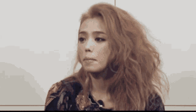 a woman with red hair is making a funny face while sitting in front of a microphone .