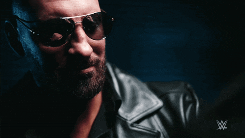 a man wearing sunglasses and a leather jacket has a w logo on the bottom right