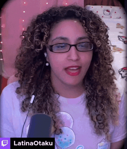 a woman with curly hair wearing glasses and a latinaotaku shirt