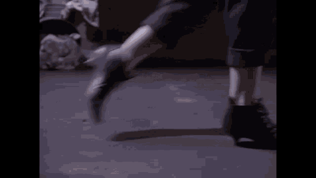 a man 's feet are standing on a pile of trash on the ground