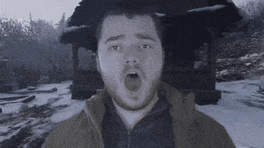 a man with his mouth open in front of a snowy scene