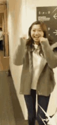 a woman is standing in a hallway with her arms outstretched