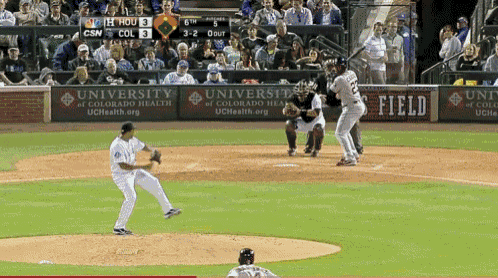 a baseball game is being played in front of a university of colorado health ad