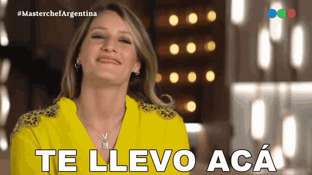 a woman in a yellow shirt is smiling and says te llevo aca