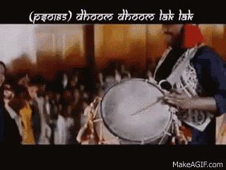 a man is playing a drum in front of a crowd in a foreign language .
