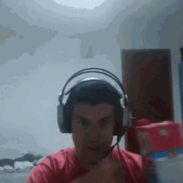 a man wearing headphones and a red shirt is holding a bottle of milk .
