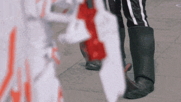 a person standing on a sidewalk holding a red and white object