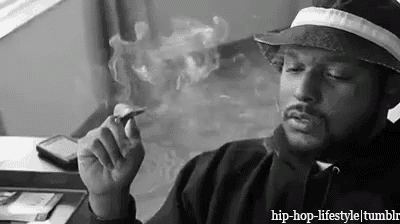 a man wearing a hat is smoking a cigarette .