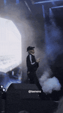 a man in a black adidas jacket is on stage
