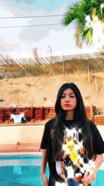 a girl wearing a t-shirt with the number 10 on it stands in front of a pool