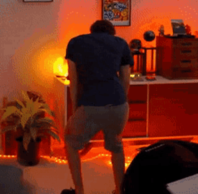 a man in a blue shirt is dancing in a room