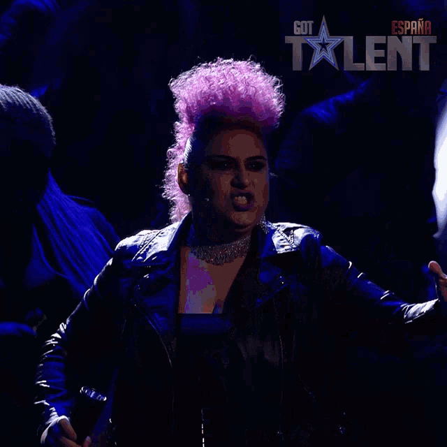 a woman with pink hair and a black jacket is on a got talent show