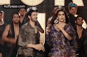 a man and a woman are dancing in front of a group of people .