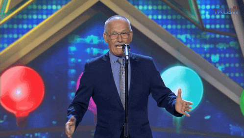 a man in a suit and tie is singing into a microphone with talent written on the bottom of the screen