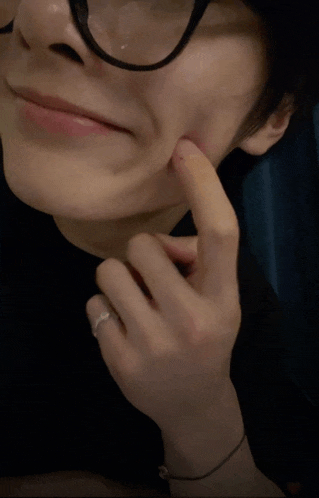 a close up of a person wearing glasses and a ring