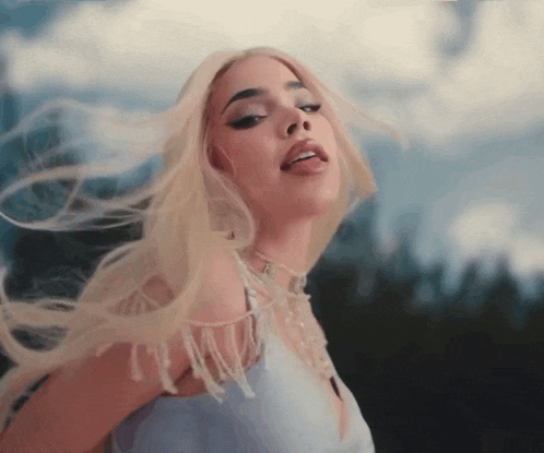 a woman with blonde hair is wearing a blue top and a choker
