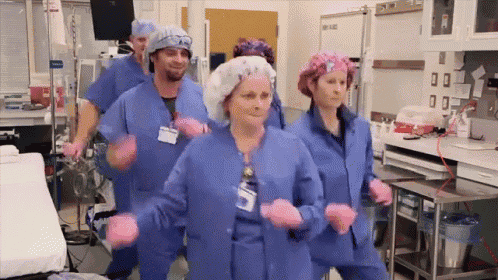 a group of nurses are dancing in a hospital room