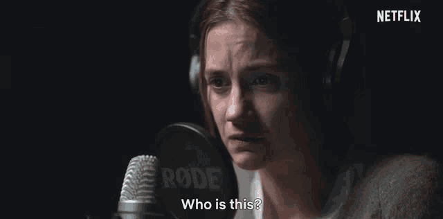 a woman wearing headphones is speaking into a microphone and asking who is this .