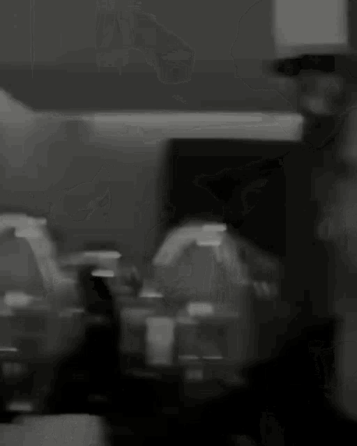 a blurry black and white photo of a man 's face .