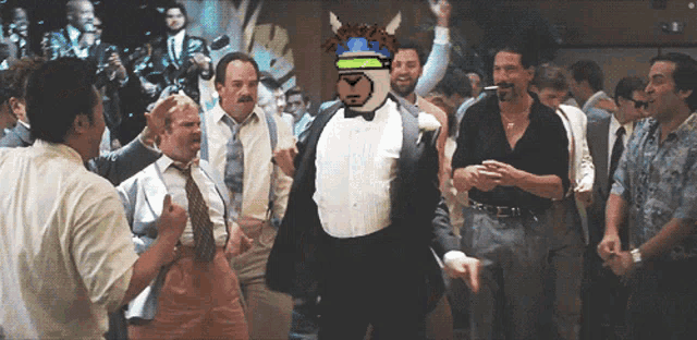 a man in a tuxedo is dancing in a crowd of men