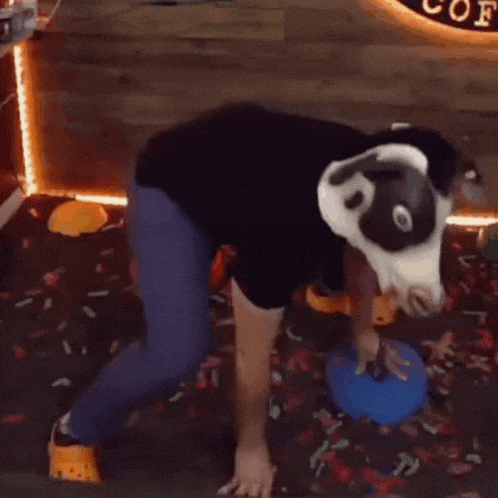 a person wearing a cow mask is standing in front of a sign that says coffee