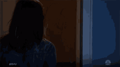 a woman is standing in front of a door with nbc written on the bottom