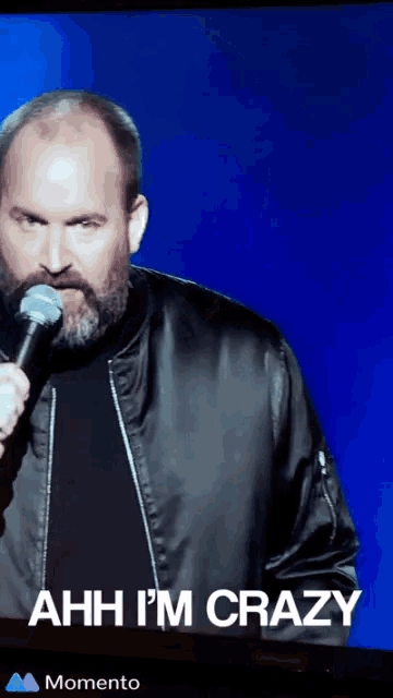 a man holding a microphone with the words " ahh i 'm crazy " above him