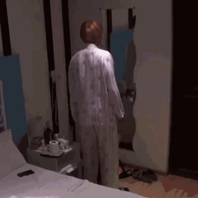 a person is standing in a bedroom with a sign that says ' oi ' on it