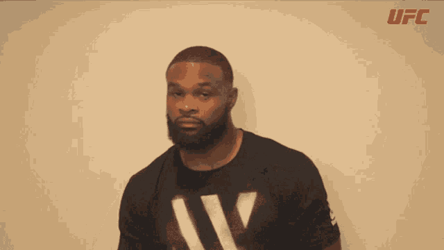 a man with a beard is wearing a black shirt with ufc written on the bottom