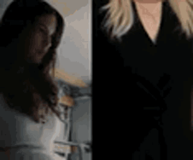 a woman in a white shirt and a woman in a black dress are standing next to each other and smiling .