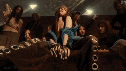 a gif of a woman sitting on a couch with the words aespagifs written on the bottom