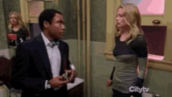 a man in a suit and bow tie is standing next to a woman in a bathroom on citytv