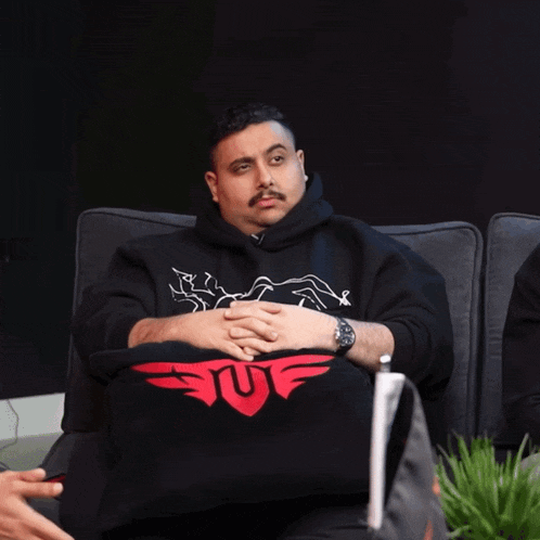 a man wearing a black sweatshirt that says suf