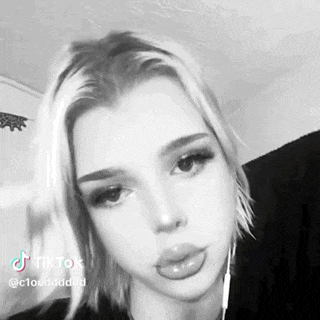 a black and white photo of a woman with short blonde hair and a nose ring .