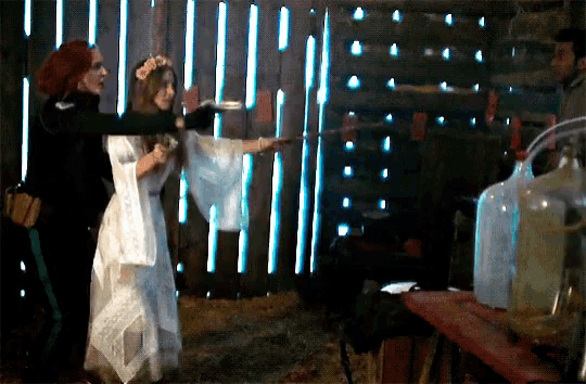 a woman in a white dress is standing next to another woman