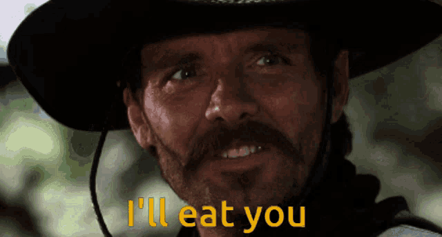 a man in a cowboy hat is saying i 'll eat you
