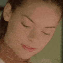 a close up of a woman 's face with a polka dot scarf around her neck