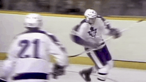 two hockey players are playing a game on the ice . one of the players has the number 21 on his jersey .