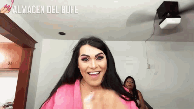 a woman in a pink robe is smiling with the words almacen del bufe behind her