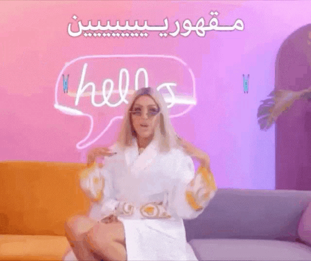 a woman in a bathrobe is sitting on a couch with a speech bubble that says hello