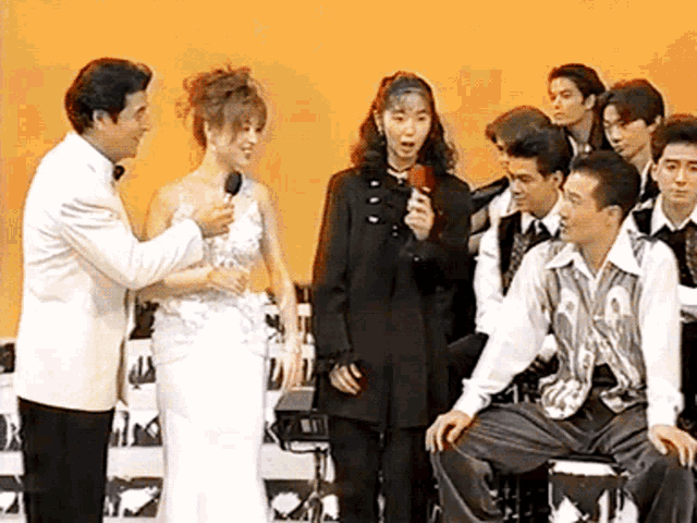 a woman in a white dress is being interviewed by a man in a white suit
